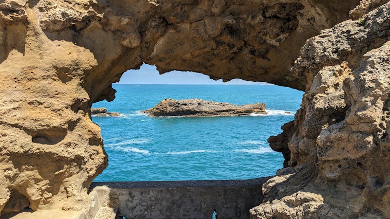 Free photo of scenic ocean view through rock arch in biarritz.jpeg
